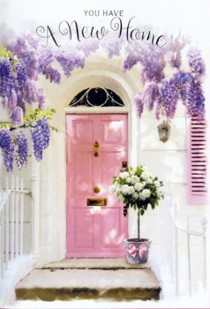 The photograph captures a tranquil Crouch End doorstep that radiates quiet optimism, as if welcoming someone home for the very first time. At the heart of the scene is a painted pink door, its colour a gentle, chalky blush that feels both modern and nostalgic. The surface is smooth but softly worn, suggesting it has already seen friendly visits and shared stories. Surrounding the frame, whitewashed walls reflect a diffused light much like the soft brightness that settles over Crouch End on a peaceful afternoon. From above, wisteria hangs in abundant cascades, washes of lavender, mauve, and pale purple forming loose curtains over the door. The blooms sway lightly, their elongated clusters layering over one another and tracing shadows onto a subtly coloured shutter to one side, evoking the leafy, residential charm of streets leading towards Crouch Hill station or Ferme Park Road. At the threshold, a simple yet elegant florist's bucket in muted grey metal holds a sumptuous arrangement of roses. The roses are creamy white with hints of ivory at their centres, each bloom opened generously to reveal spiralling petals that look almost like folded silk. Nestled among them, soft green foliage provides contrast and depth, its edges a little ruffled as though just picked from a nearby garden. A soft pink ribbon encircles the bucket and ties in a graceful bow, the satin ends resting lightly against the stone step and mirroring the door's hue. You can imagine the delicate scents mingling in the air, a blend of heady wisteria and refined rose perfume. It's easy to picture this as a thoughtful housewarming gift for a new address near Crouch End Broadway: an arrangement that quietly turns a simple doorstep into an emblem of welcome, comfort, and the excitement of starting fresh.